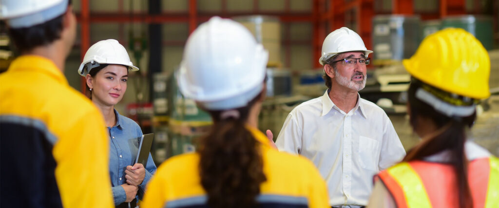 Group of construction workers in a meeting with three of them out of focused in the fore group and two of them in the background in focus