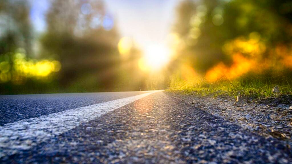 Ground level photo of street with sunbeam lens flare