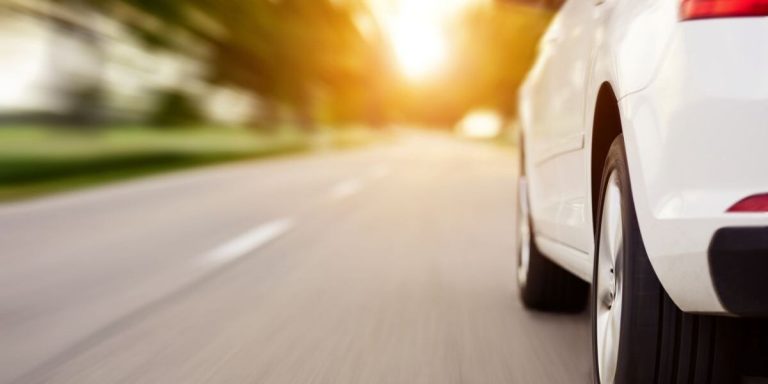 Close up of car driving, with a focus on the cars wheel