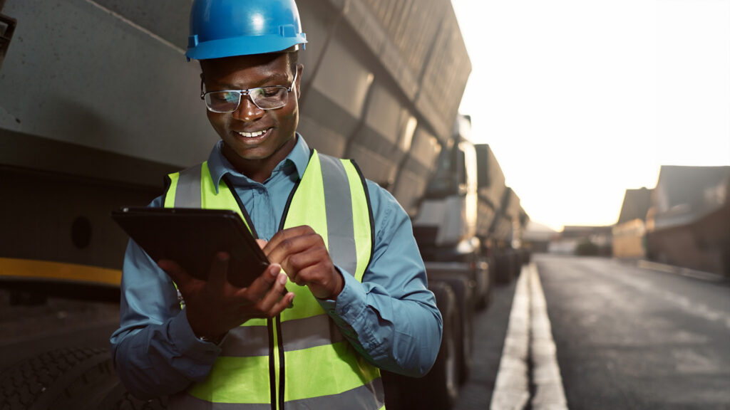 Close up of a worker on tablet review documents next to cargo truck