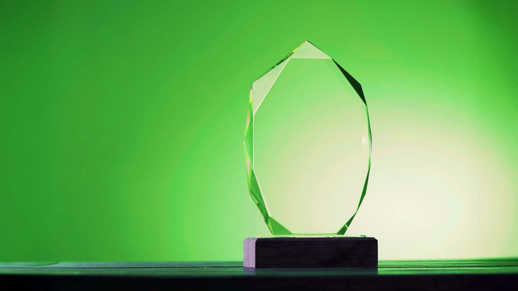 close up of crystal trophy against green background