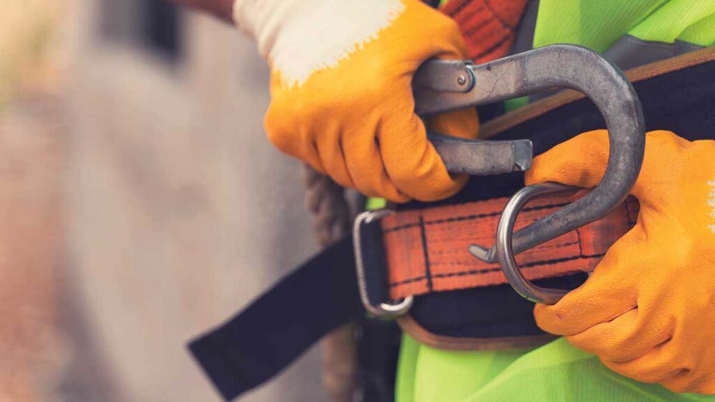 Close of a man clipping his safety harness